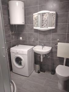 uma casa de banho com uma máquina de lavar roupa e um lavatório em Apartman Ivano em Kaštela