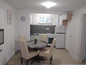 uma cozinha e sala de jantar com mesa e cadeiras em Apartman Ivano em Kaštela