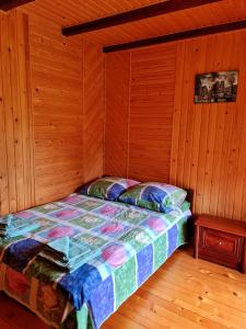 a bedroom with a bed in a wooden room at Приватна Садиба Потічок in Slavske