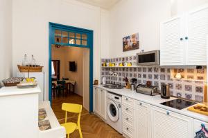 a kitchen with white cabinets and a washer and dryer at ❁ Casa Frida ❁ Exceptional Stay In Old Town! ❁ in Tbilisi City