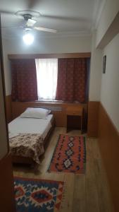 イスタンブールにあるKadikoy Otelのベッドルーム1室(ベッド1台、窓、ラグ付)