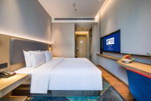 a bedroom with a large white bed and a tv at Holiday Inn Express Shenzhen Nanshan by IHG in Shenzhen
