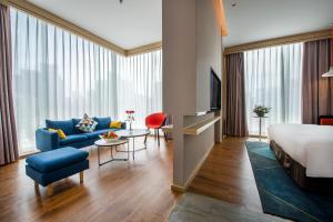 a hotel room with a bed and a living room at Holiday Inn Express Shenzhen Nanshan by IHG in Shenzhen