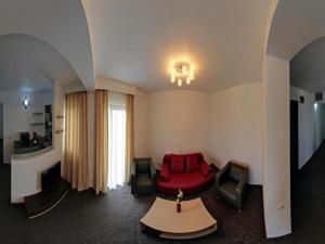 ein Wohnzimmer mit einem roten Sofa und einem Tisch in der Unterkunft Hotel Solymar in Mangalia