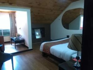 - une chambre avec un lit et une grande fenêtre dans l'établissement Maisonette Hotels & Resorts Naran, à Mānsehra