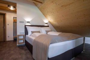 a bedroom with a large bed with wooden ceilings at Rezidence Tři Studně in Tři Studně