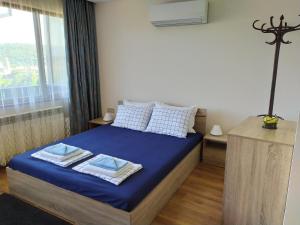 1 dormitorio con cama con sábanas azules y ventana en Stefi house en Veliko Tŭrnovo