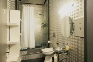 ein Badezimmer mit einem WC, einem Waschbecken und einem Spiegel in der Unterkunft B@Home Apartments in Sanem