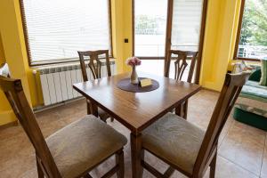 jadalnia z drewnianym stołem i krzesłami w obiekcie Апартамент Слънчев Ден w Bałcziku