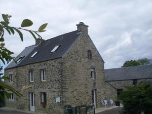 duży ceglany budynek z czarnym dachem w obiekcie Chambres D'hôtes au Saint Avit w mieście Huisnes-sur-Mer