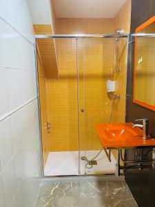 a bathroom with a glass shower and a sink at Aparthotel G3 Galeon in Madrid