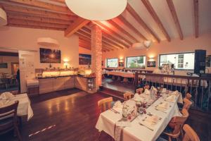 a restaurant with white tables and chairs and a kitchen at Hotel Zum Mühlental in Buch