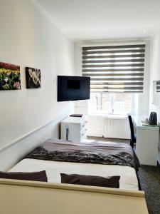 a bedroom with a bed and a flat screen tv at Rushmore Hotel in London