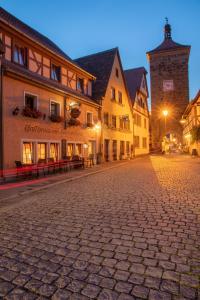 a cobblestone street in a medieval town at night at Hotel Am Siebersturm in Rothenburg ob der Tauber