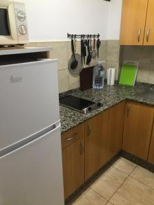 kuchnia z białą lodówką i drewnianymi szafkami w obiekcie Yumbo Beach Apartment 2 with high speed free internet w mieście San Bartolomé