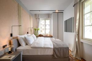 a bedroom with a large white bed with a window at Zlata Ladjica Boutique Hotel in Ljubljana