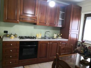 a kitchen with wooden cabinets and a sink and a stove at Corso Roma in Cirò Marina