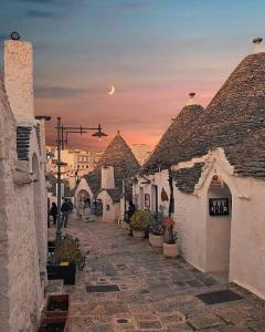 una strada in una città con edifici e un tramonto di Trullo Nobilis ad Alberobello