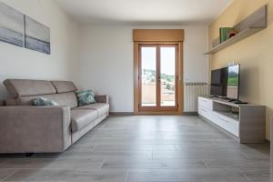 ein Wohnzimmer mit einem Sofa und einem TV in der Unterkunft A Casa di Lelia in Muggia
