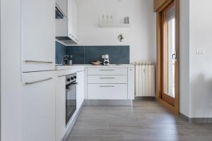 a kitchen with white cabinets and a tile floor at A Casa di Lelia in Muggia