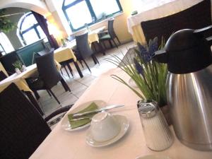 Una mesa en un restaurante con un jarrón de flores. en Krämerwirt Hotel-Gasthof, en Strasswalchen