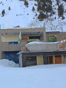 a house with snow on the roof of it at Hotel Mi-Amore in Naran