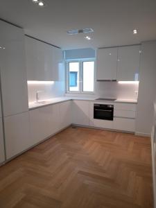 una cucina con mobili bianchi e pavimento in legno di Lisbon, Wifi, AC a Lisbona