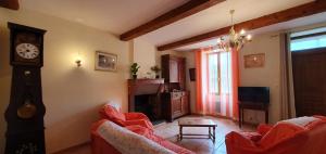 sala de estar con sofá y reloj en La maison de mon enfance ! Au cœur du Minervois !, en Félines-Minervois