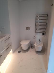ein weißes Bad mit einem WC und einem Waschbecken in der Unterkunft Lisbon, Wifi, AC in Lissabon