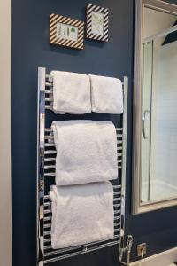 a towel rack with white towels in a bathroom at The Townhouse in Stratford-upon-Avon