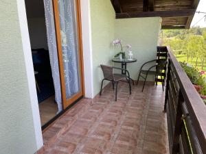 einen Balkon mit einem Tisch und Stühlen darauf in der Unterkunft Aria Room - Rastoke in Slunj