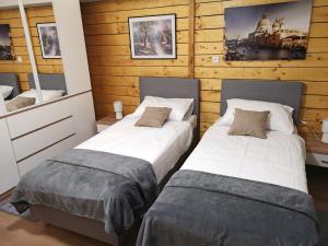 Duas camas num quarto com paredes de madeira em Sobe Marija Varaždin, Hrašćica em Sračinec