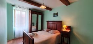 Un dormitorio con una cama y una lámpara y una ventana. en La maison de mon enfance ! Au cœur du Minervois !, en Félines-Minervois