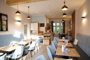 a restaurant with wooden tables and white chairs at Pension Moselvilla 1900 in Cochem