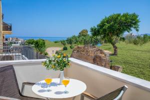 a table with two wine glasses and a vase with flowers at Forum City Apartments in Chania