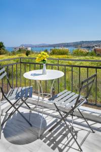 una mesa y sillas en un balcón con vistas al océano en Forum City Apartments, en La Canea