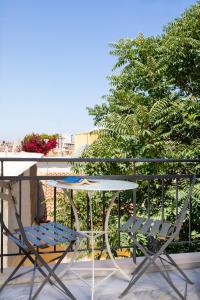 un tavolo e 2 sedie seduti su un balcone di Forum City Apartments a Chania