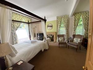 una camera da letto con un grande letto bianco con una grande finestra di Haselbury Mill a Crewkerne