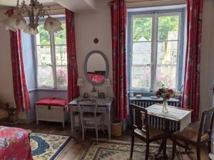 a living room with a table and a mirror at Sweeting's B & B Chailland in Chailland