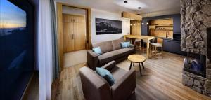 a living room with a couch and a table and a kitchen at Monte Móry Apartmán in Vysoke Tatry - Strbske Pleso