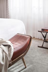 a bedroom with a bed and a chair and a table at The Norman Tel Aviv in Tel Aviv