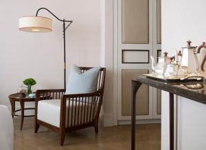 a living room with a table and a chair and a lamp at The Norman Tel Aviv in Tel Aviv