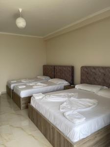 three beds are lined up in a room at Hotel Fredi Shengjin in Shëngjin +9 photos