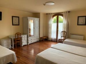 a bedroom with two beds and a desk and a mirror at Hotel Alameda in Zarautz