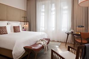 a hotel room with a large bed and a desk at The Norman Tel Aviv in Tel Aviv