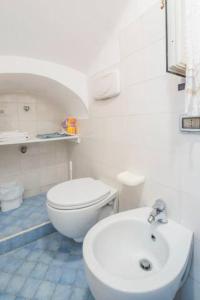 a white bathroom with a toilet and a sink at Casa San Michele in Minori