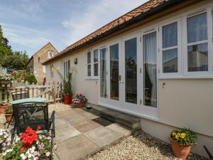 a house with sliding glass doors and a patio at Glebe Lodge in Westbury-sub-Mendip
