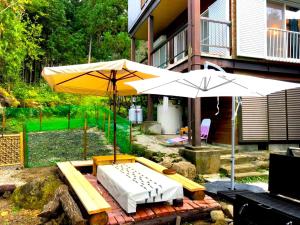 a patio with two white umbrellas and a bench at THE HIGHEST VILLA IZUMI - Vacation STAY 07935v in Nakatsugawa