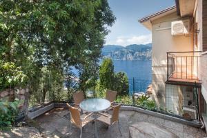 a patio with a table and chairs and a view of the water at Apartment Windows On The Lake in Malcesine
