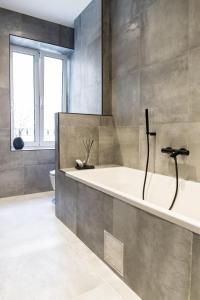 a bathroom with a bath tub and a toilet at Apartments Dolac in Rijeka